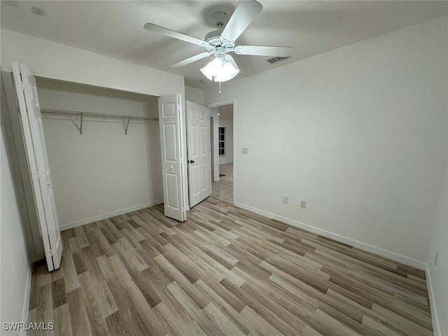 unfurnished bedroom featuring light hardwood / wood-style floors, ceiling fan, and a closet