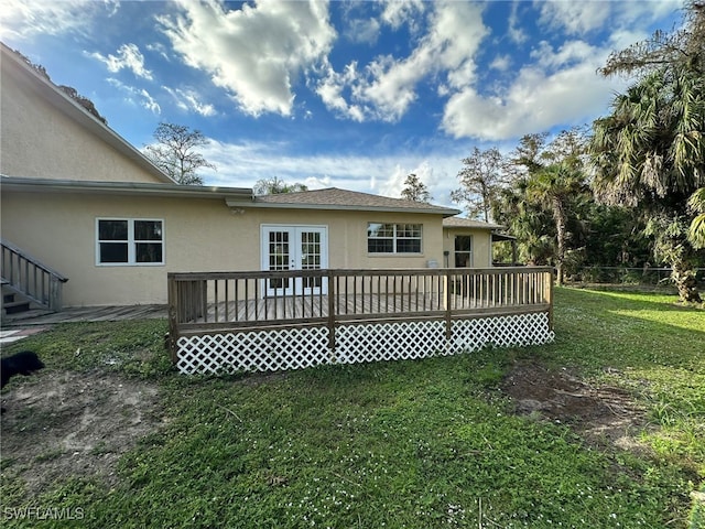 rear view of house with a deck and a lawn