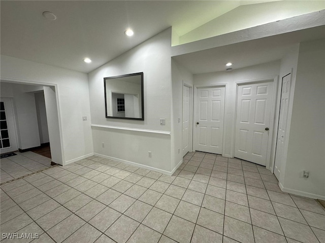 unfurnished living room with light tile patterned flooring and vaulted ceiling