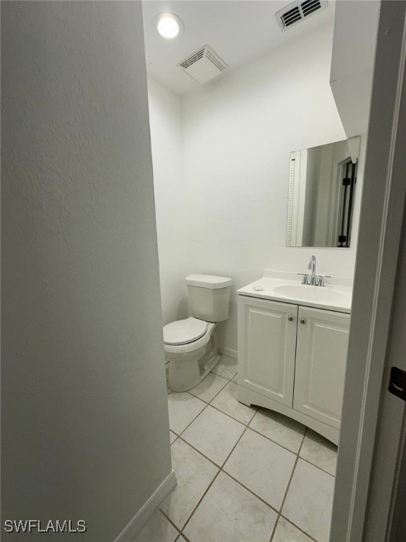 bathroom featuring tile patterned flooring, vanity, and toilet