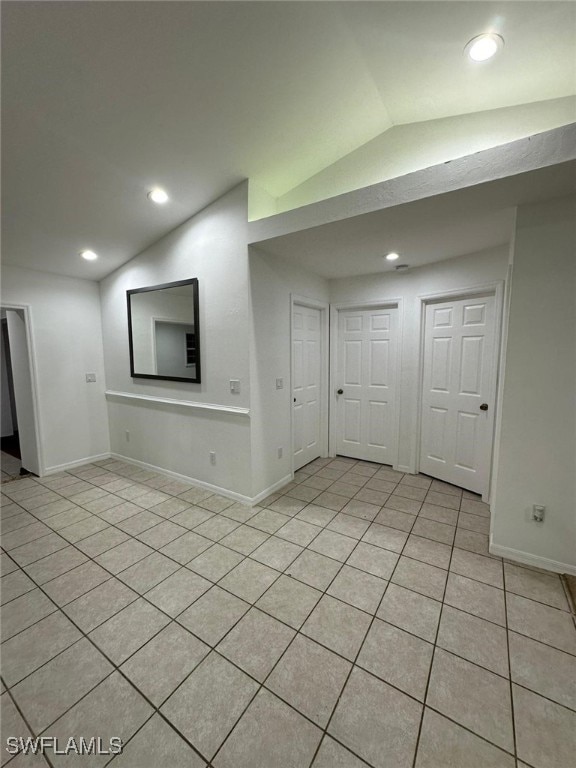 unfurnished living room with lofted ceiling and light tile patterned floors