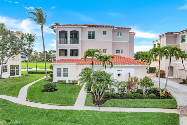 mediterranean / spanish house featuring a balcony and a front lawn