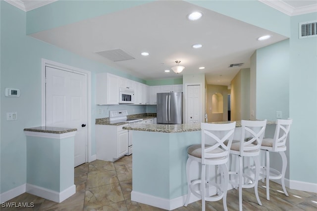 kitchen featuring kitchen peninsula, white appliances, and white cabinetry