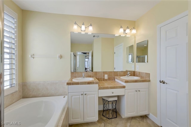 bathroom featuring tiled tub and vanity