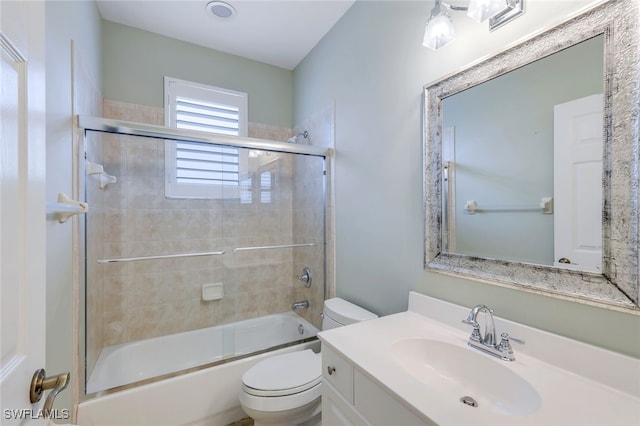 full bathroom featuring enclosed tub / shower combo, vanity, and toilet