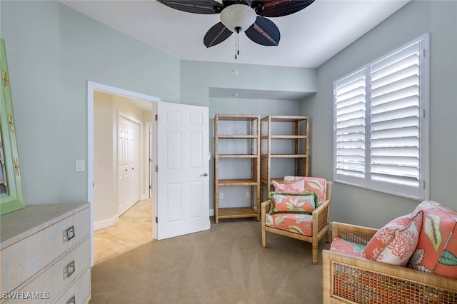 living area featuring ceiling fan and light colored carpet