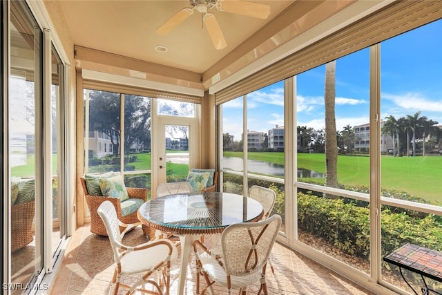 sunroom with a water view and ceiling fan