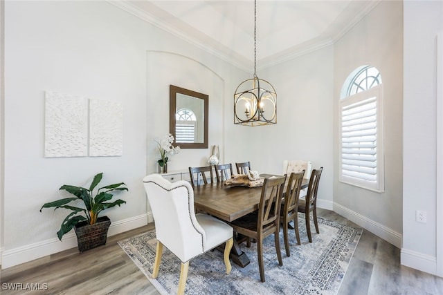 dining area featuring ornamental molding, a notable chandelier, and wood-type flooring