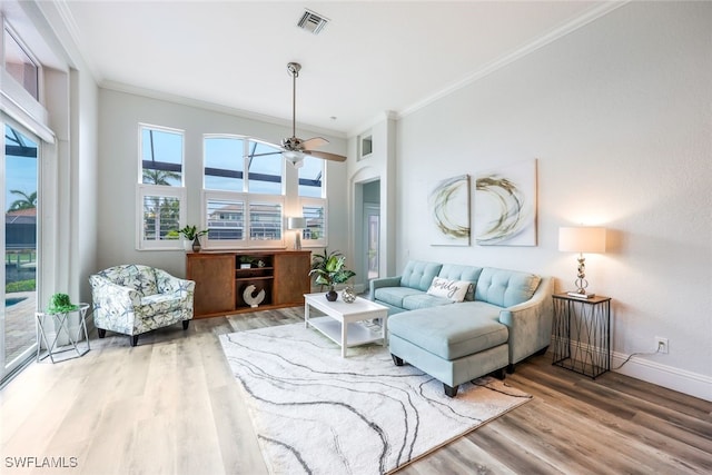 living room featuring ornamental molding, wood-type flooring, and ceiling fan