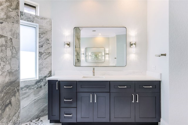 bathroom featuring tile walls, vanity, ornamental molding, and walk in shower