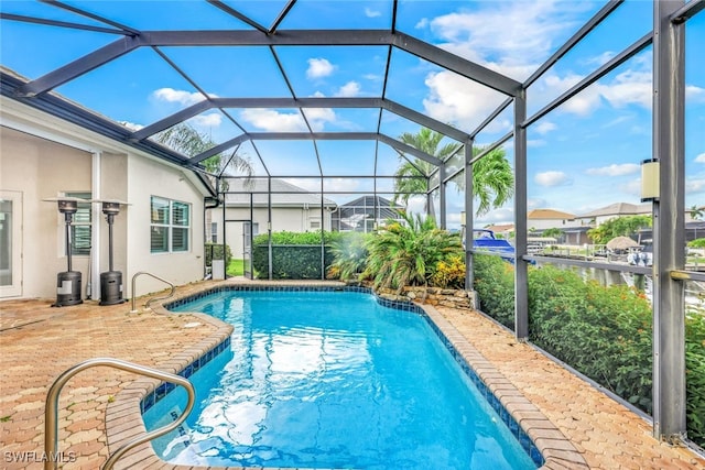 view of swimming pool with a water view, a patio area, and a lanai