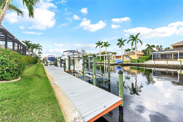 dock area featuring a water view, a lanai, and a lawn