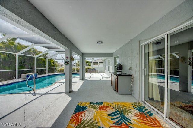 view of swimming pool with glass enclosure and a patio