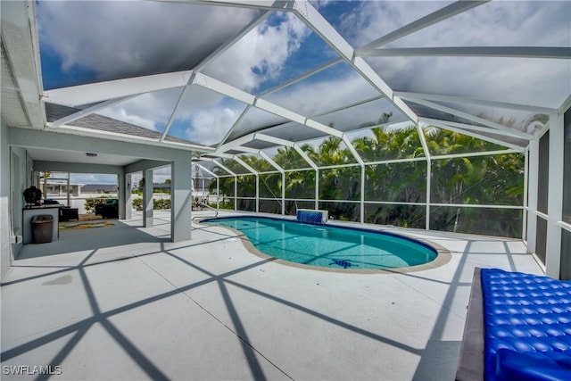 view of swimming pool with glass enclosure and a patio