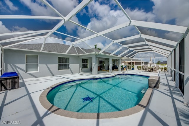 view of swimming pool with glass enclosure and a patio area