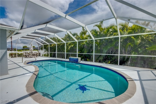 view of pool with a lanai, pool water feature, and a patio area