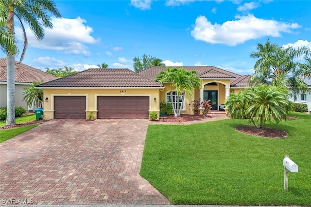 mediterranean / spanish house featuring a garage and a front lawn