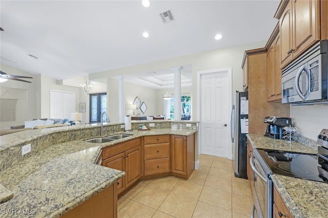 kitchen featuring appliances with stainless steel finishes, ceiling fan with notable chandelier, a healthy amount of sunlight, decorative columns, and sink