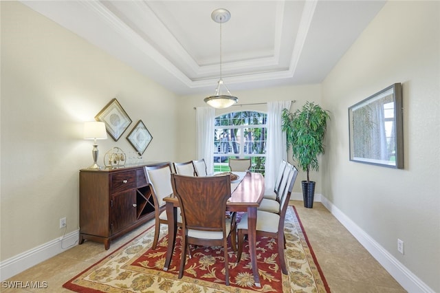 dining area with light tile patterned flooring and a raised ceiling