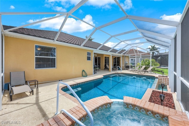 view of swimming pool featuring glass enclosure, an in ground hot tub, and a patio area