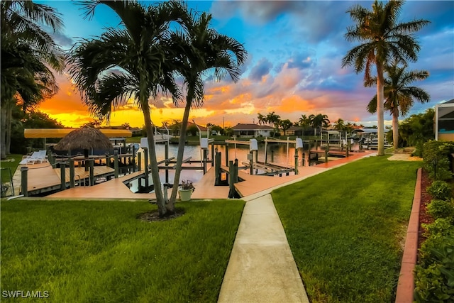 dock area with a water view and a yard