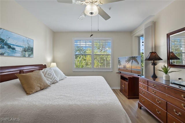 bedroom featuring light hardwood / wood-style floors, multiple windows, and ceiling fan