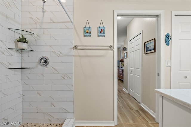 bathroom featuring vanity, hardwood / wood-style floors, and tiled shower