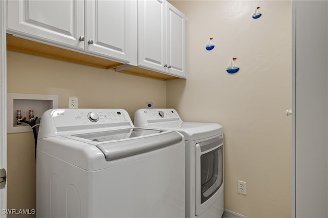 washroom featuring independent washer and dryer and cabinets