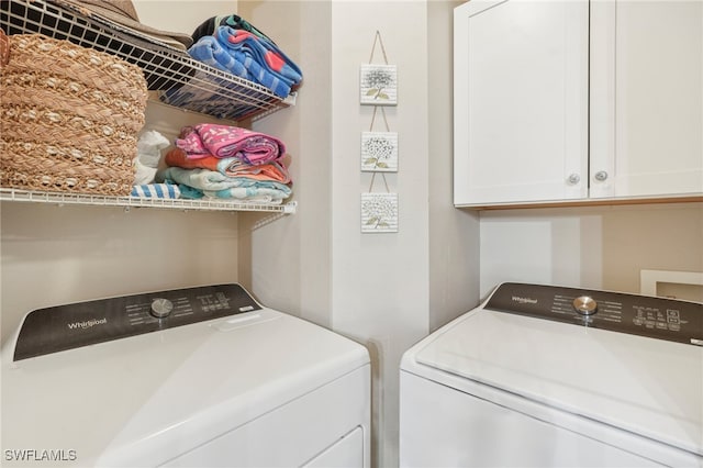 laundry area featuring washer and dryer and cabinets