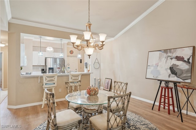 dining space featuring light hardwood / wood-style floors, ornamental molding, and a notable chandelier