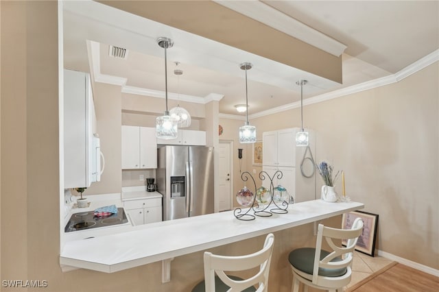 kitchen with white cabinets, kitchen peninsula, stainless steel refrigerator with ice dispenser, a breakfast bar area, and black range oven