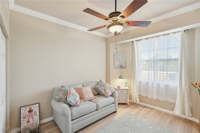 living room featuring light hardwood / wood-style flooring, ceiling fan, and crown molding