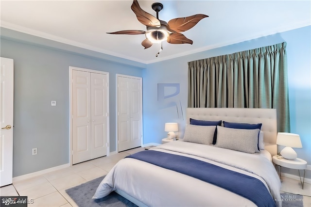 bedroom featuring ceiling fan, multiple closets, crown molding, and light tile patterned floors