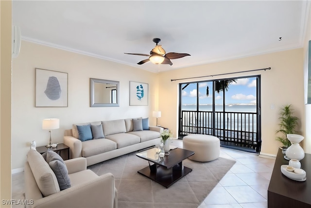 tiled living room with ceiling fan, crown molding, and a water view