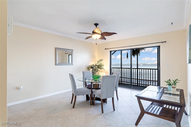 tiled dining space with ceiling fan and crown molding