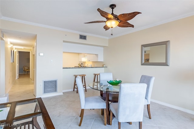 dining room with ceiling fan, light tile patterned flooring, and crown molding