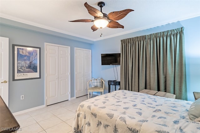 bedroom with ceiling fan, light tile patterned floors, two closets, and ornamental molding