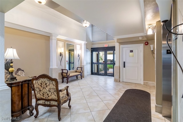 tiled entrance foyer featuring decorative columns and crown molding