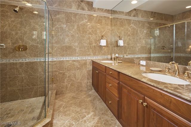 bathroom with vanity, tile walls, and a shower with door