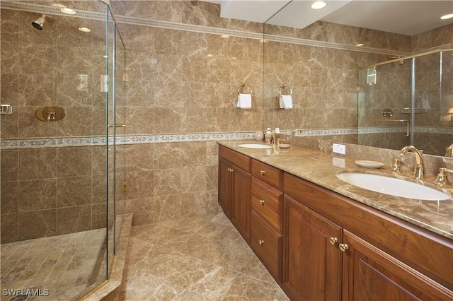 bathroom featuring double vanity, a stall shower, tile walls, and a sink