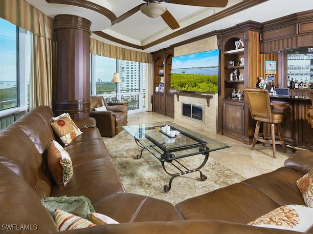 tiled living room featuring a high end fireplace, crown molding, bar area, and ceiling fan