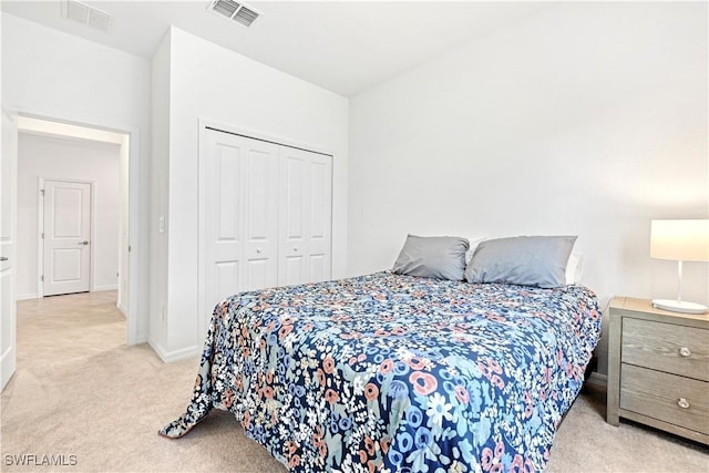 bedroom with baseboards, a closet, visible vents, and light colored carpet