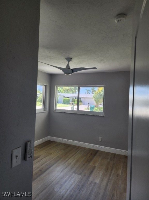 spare room featuring ceiling fan, a textured ceiling, and wood-type flooring