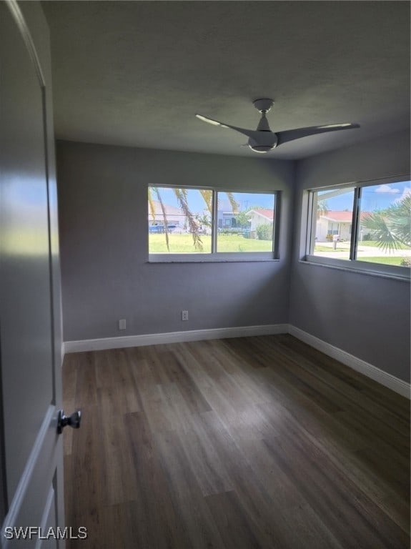 unfurnished room featuring ceiling fan and dark hardwood / wood-style flooring