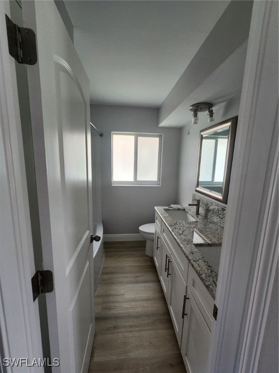 full bathroom featuring shower / tub combination, hardwood / wood-style floors, vanity, and toilet