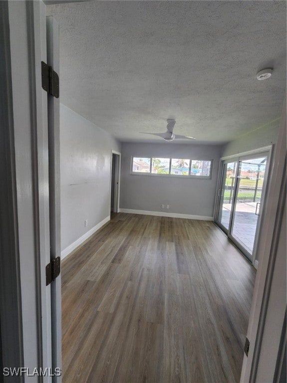 spare room featuring a textured ceiling, ceiling fan, and hardwood / wood-style flooring