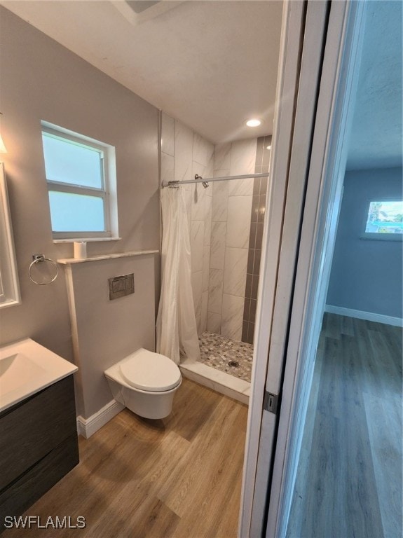 bathroom with walk in shower, vanity, hardwood / wood-style floors, and toilet