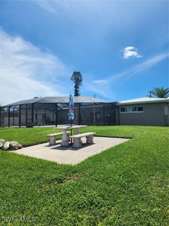 view of yard featuring glass enclosure and a patio area