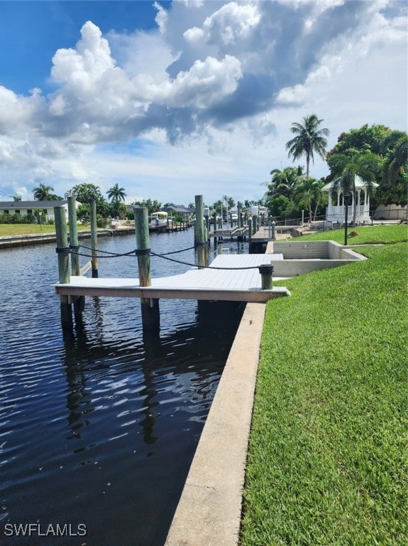 dock area with a lawn and a water view