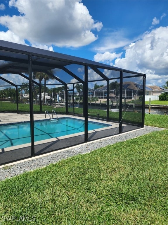 view of pool with a yard and a lanai